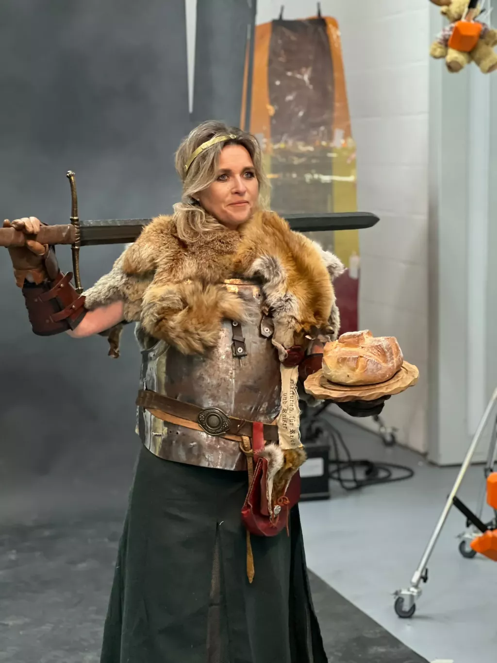 Eine Frau in Ritterkostüm mit einem Brot in der Hand posiert für das Fotoshooting der Kampagne 