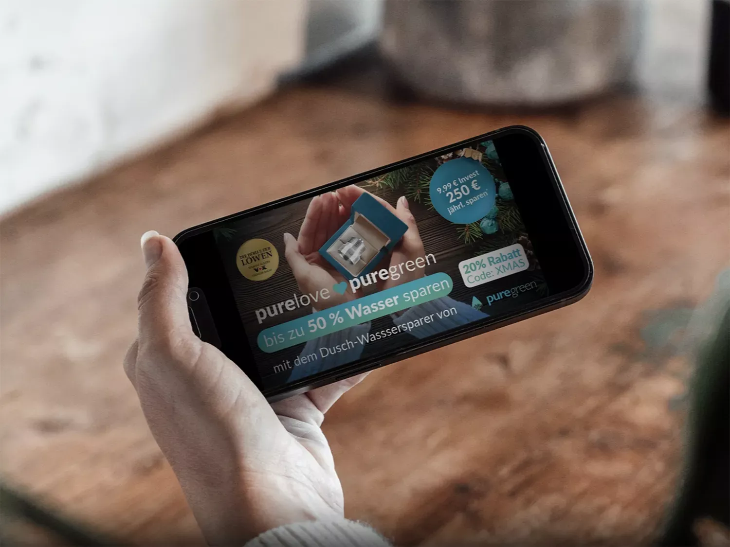 Weibliche Person hält iPhone in der Hand und zeigt ein Video der Marke Puregreen.